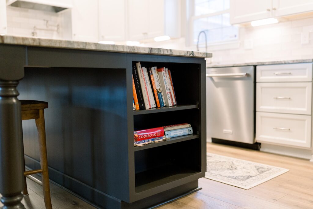 Dark gray island with built-in bookshelf on the end. 