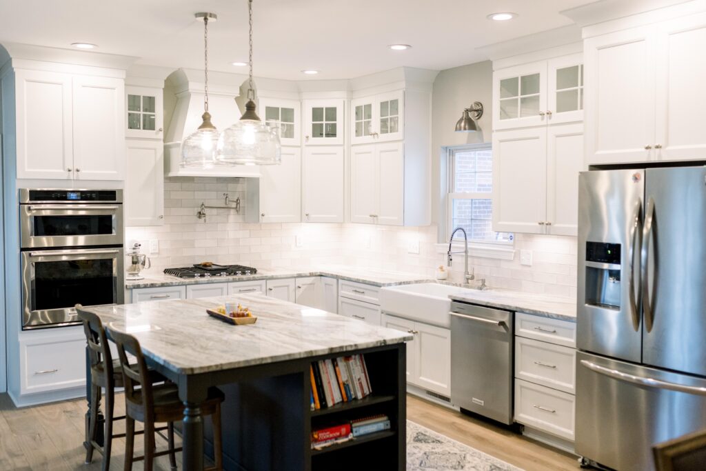 Kitchen with white cabinets to the ceiling, granite countertops, and stainless appliances. 